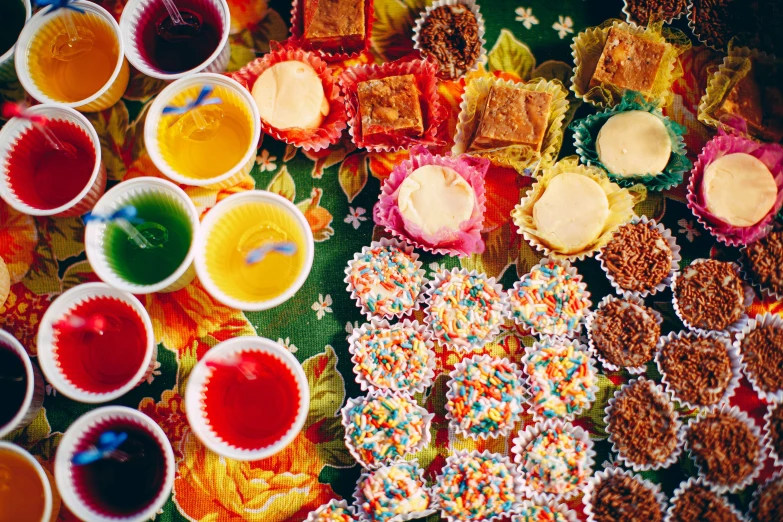 a table topped with lots of different types of cupcakes, unsplash, process art, 1970s philippines, square, drinks, candy - coated