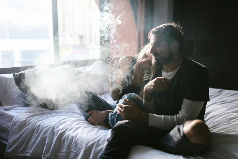 a man sitting on top of a bed next to a woman, by Lee Loughridge, pexels contest winner, smoke from mouth, pot leaf, happy family, lachlan bailey