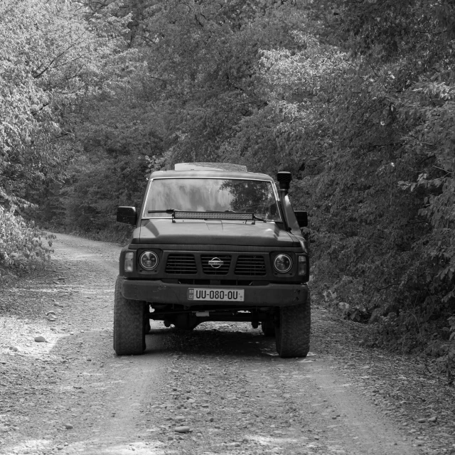 a black and white photo of a truck on a dirt road, a black and white photo, pixabay, russian lada car, in green forest, 2 4 0 p footage