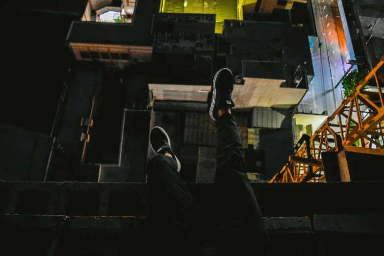 a person walking up a flight of stairs at night, pexels contest winner, sitting in a crane, sneaker photo, upside - down building, parkour
