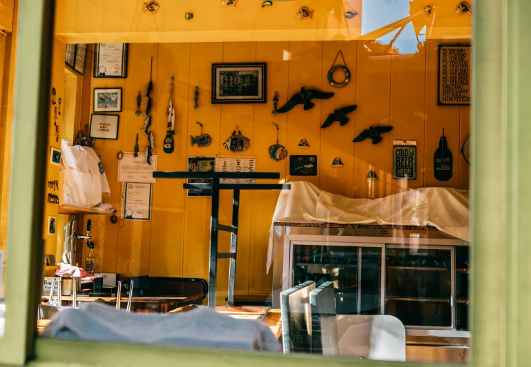 a view of a living room through a window, by Lee Loughridge, unsplash, hanging beef carcasses, yellow walls, iconostasis in the bar, weapon shop interior