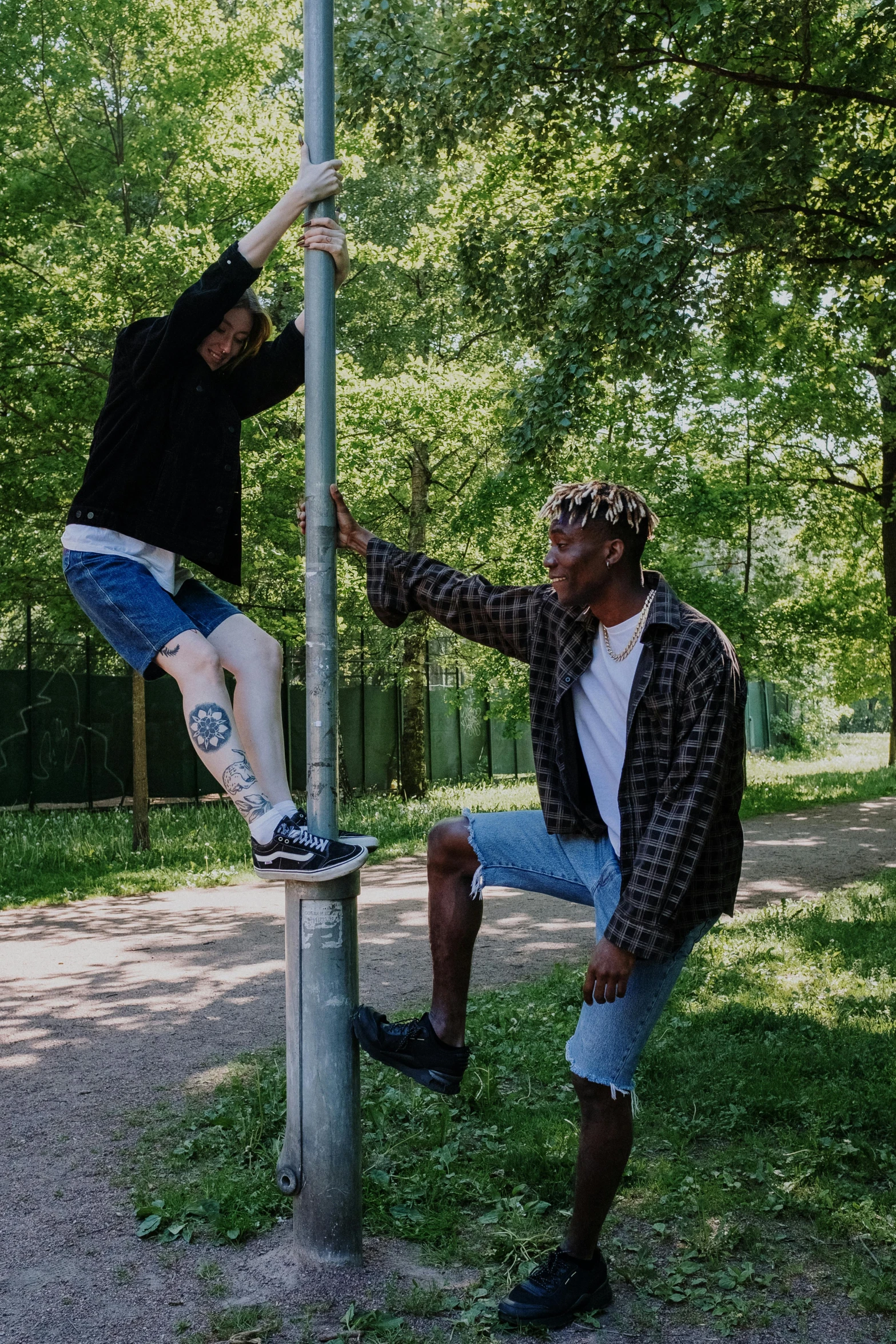 a couple of men standing on top of a pole, trending on pexels, realism, bladee from drain gang, in a park, bleached, leg high