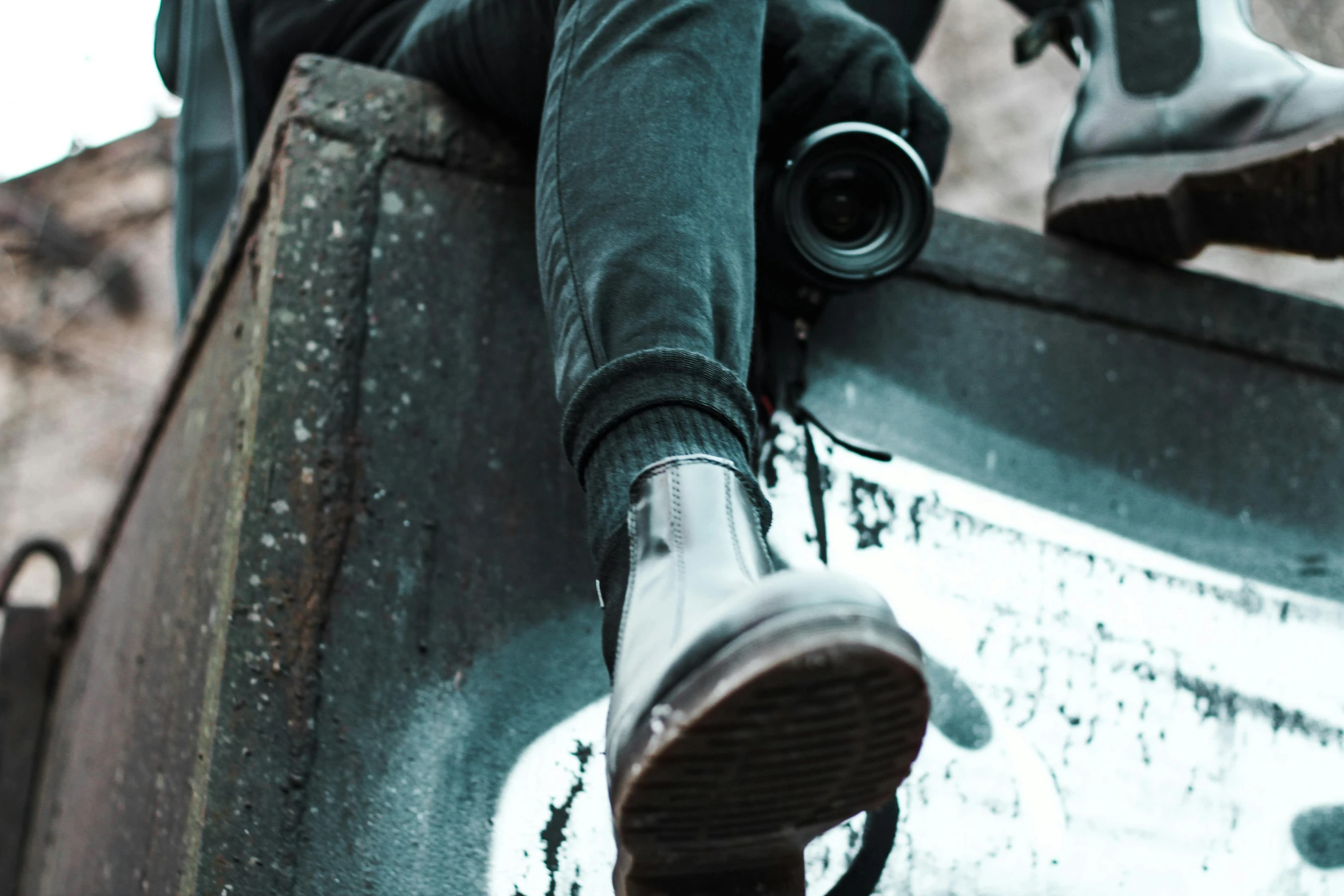 a person sitting on top of a metal object, pexels contest winner, photorealism, black boots, camera looking down upon, side view close up of a gaunt, desaturated