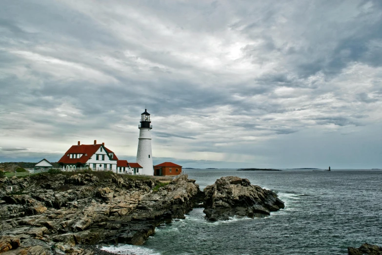 a lighthouse sitting on top of a rocky cliff next to the ocean, by Andrew Domachowski, pexels contest winner, new england architecture, white marble buildings, brooding clouds', 2000s photo