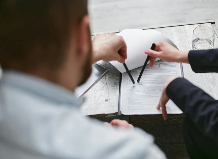 a couple of people that are sitting at a table, pexels contest winner, holding a clipboard, paper cut out, close up shot from the top, professional work