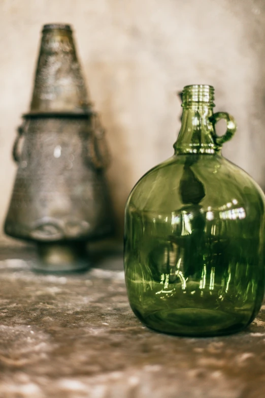 a green glass bottle sitting on top of a counter, a still life, unsplash, renaissance, traditional corsican, lantern, pot, large tall