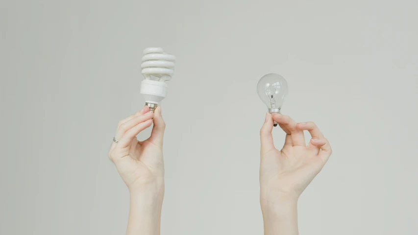 a person holding two light bulbs in their hands, trending on pexels, light and space, varying thickness, sustainable materials, flat minimalistic, laura watson