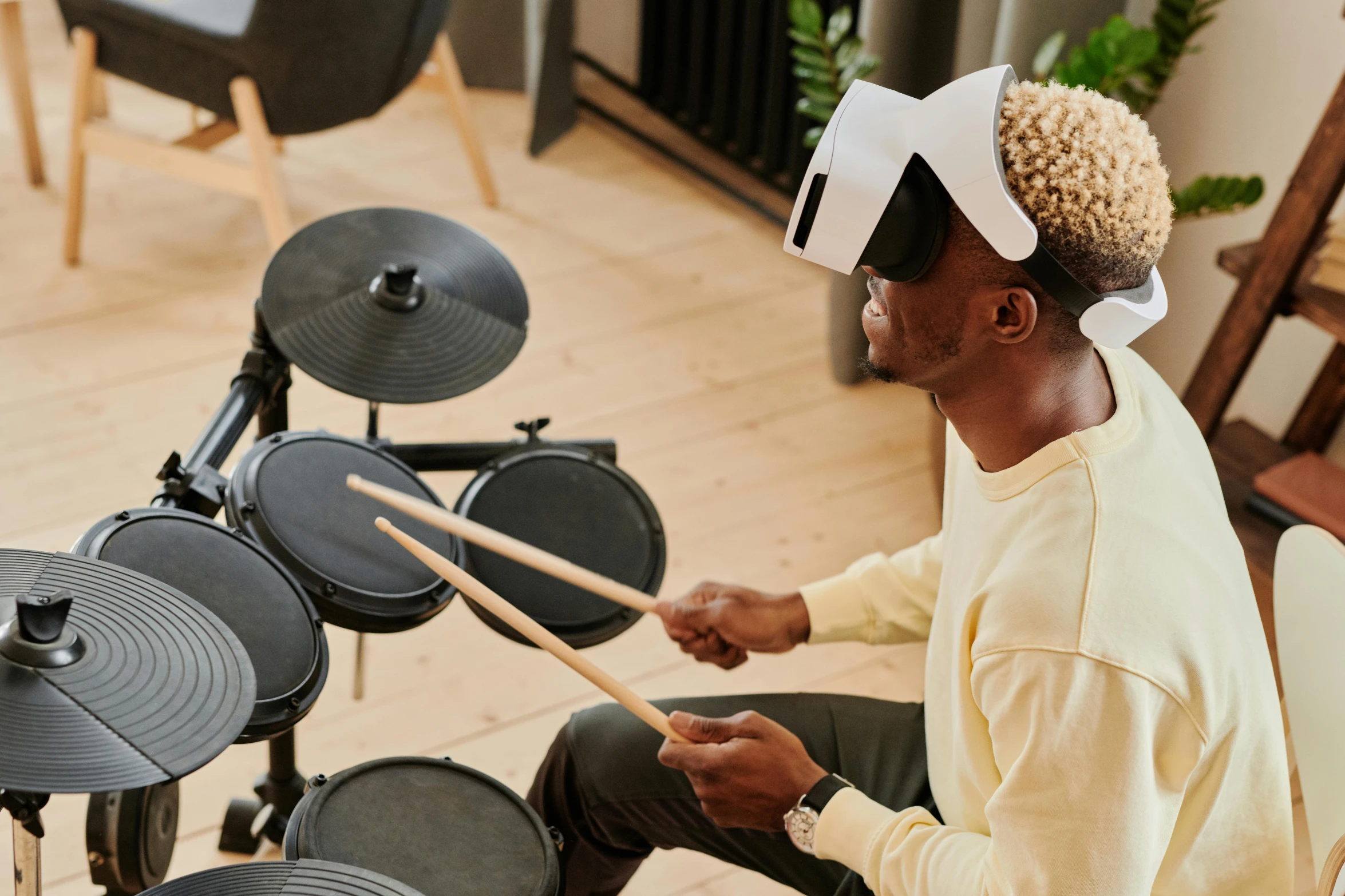 a man sitting in front of a drum set, trending on pexels, interactive art, oled visor over eyes, nerdy music teacher with phd, playing games, promo image