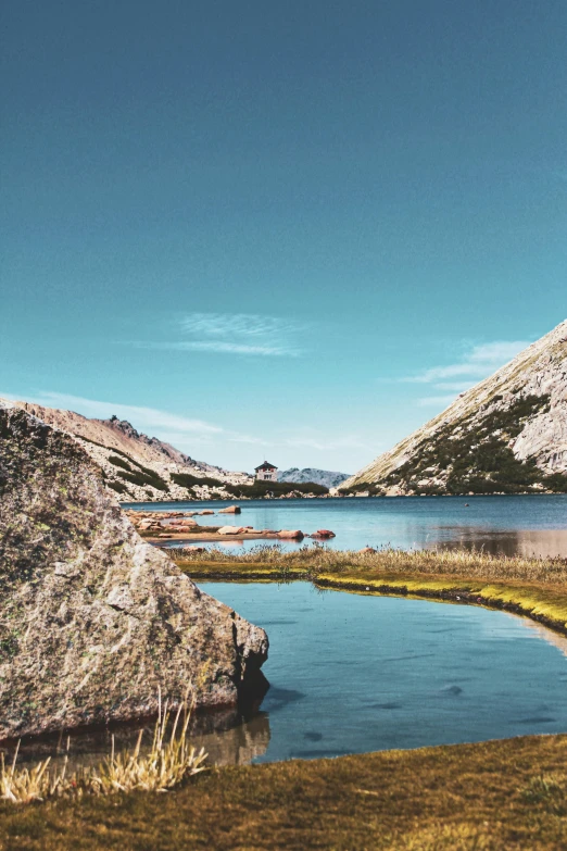 a body of water sitting on top of a lush green hillside, by Carlo Martini, unsplash, small canoes, mountain lake in sierra nevada, vintage color photo, today\'s featured photograph 4k