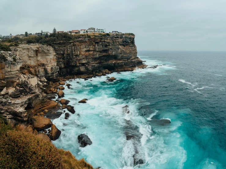 a large body of water next to a cliff, pexels contest winner, sydney, ocean spray, the village on the cliff, 2 0 0 0's photo
