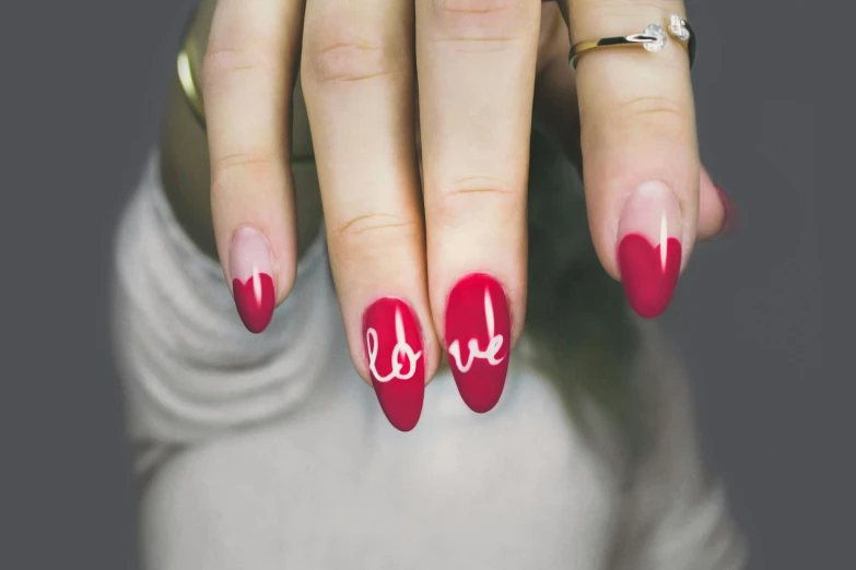 a close up of a person's hand with a red and white manicure, trending on pexels, red writing, love moive, colour splash, long nails