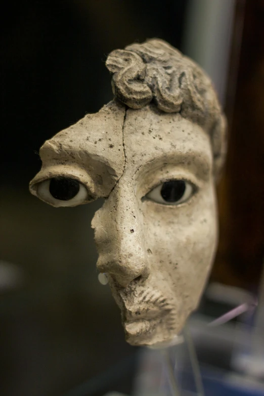 a close up of a sculpture of a person's face, inspired by Diego Giacometti, renaissance, subject made of cracked clay, from commedia dell'arte, tiny statue on display, greek nose