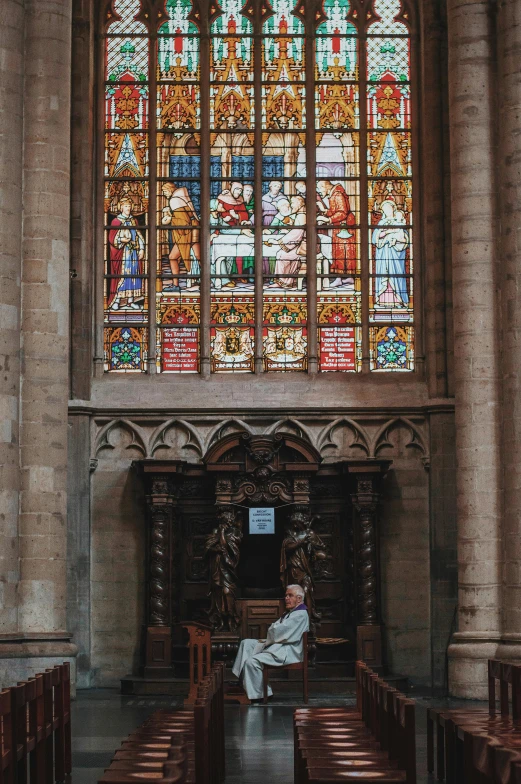 a man sitting on a bench in front of a stained glass window, by Barthélemy d'Eyck, pexels contest winner, renaissance, alabaster gothic cathedral, sitting in fancy chair, ox, belgium