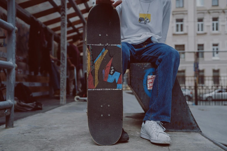 a man sitting on a bench holding a skateboard, a picture, by Attila Meszlenyi, graphic tees, sitting on top a table, medium close-up shot, mixed art