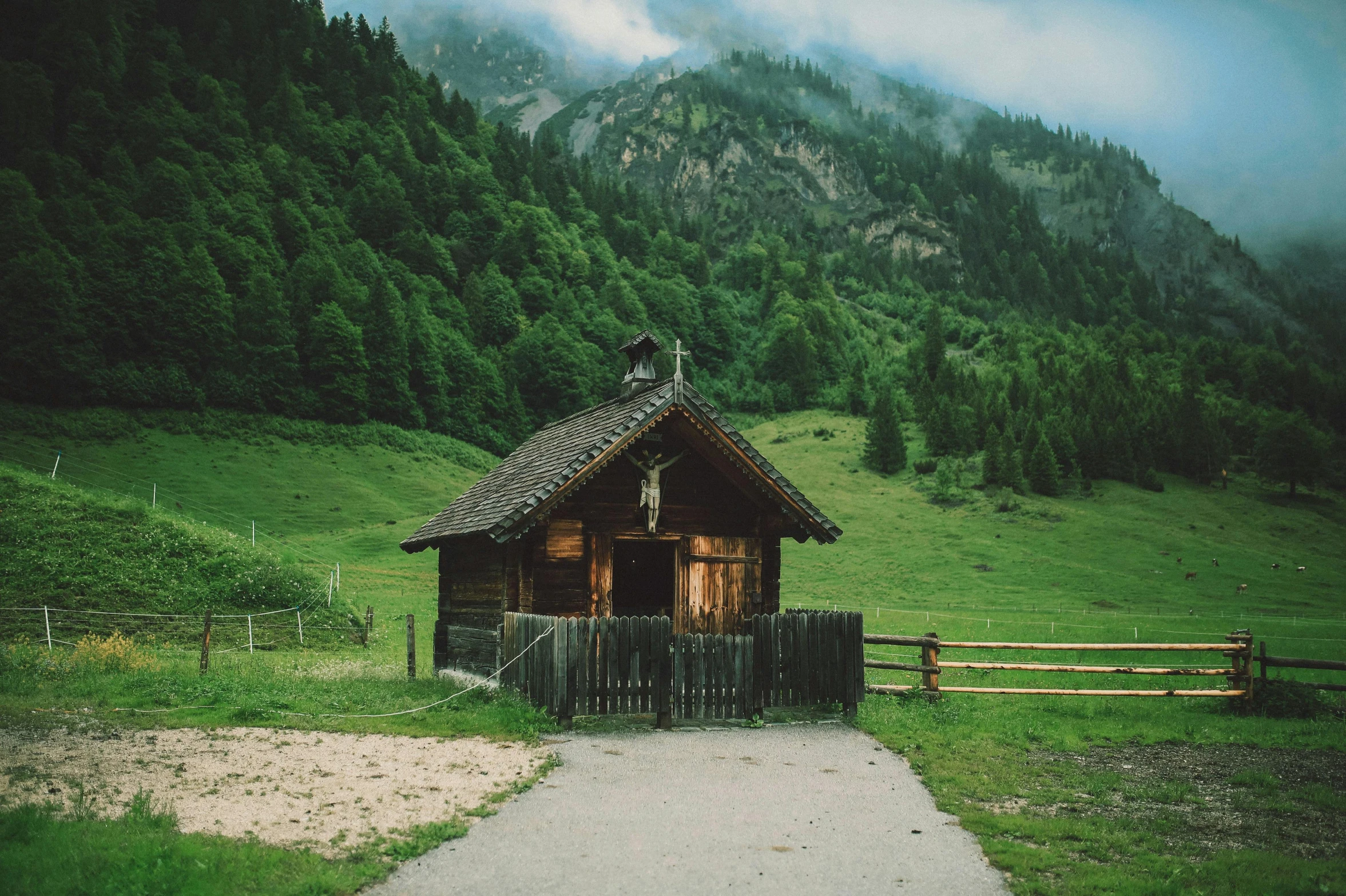 a small wooden house sitting on top of a lush green hillside, by Sebastian Spreng, pexels contest winner, renaissance, church, nostalgic vibes, hut, evergreen valley