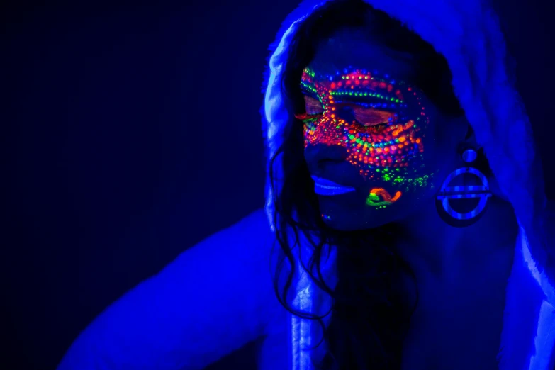 a woman with black light on her face, pexels, psychedelic art, photograph of three ravers, neon tattoo, dark blue neon light, intricate oil pastel glow
