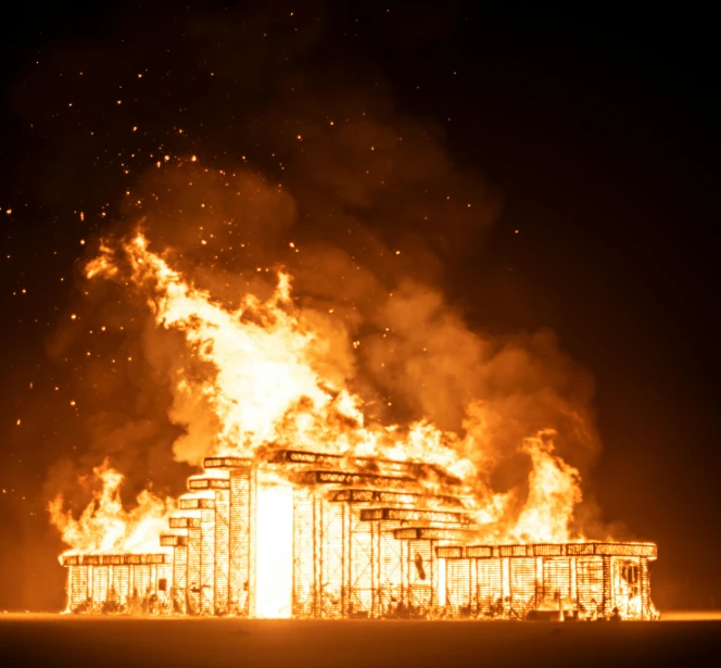 a burning building in the middle of a field, by Hannah Tompkins, pexels contest winner, conceptual art, burning man nevada, set at night, construction, the fire is made of binary code