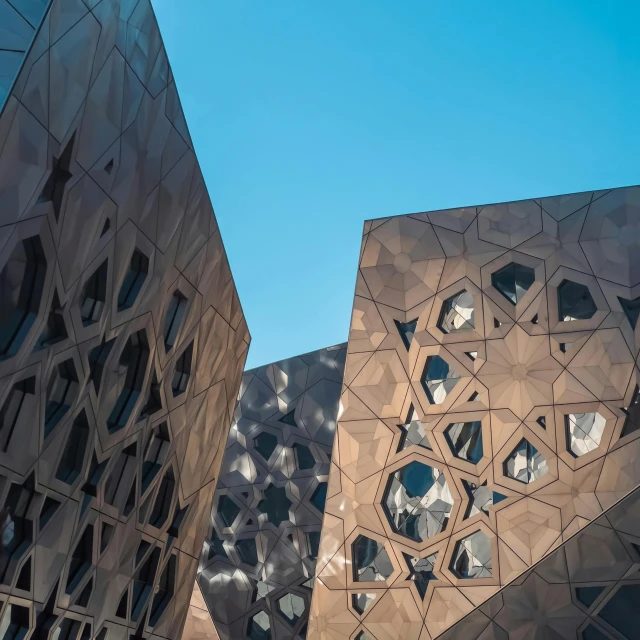 a couple of buildings that are next to each other, inspired by Zaha Hadid, pexels contest winner, voronoi pattern, futuristic marrakech, angular metal, modular graphene