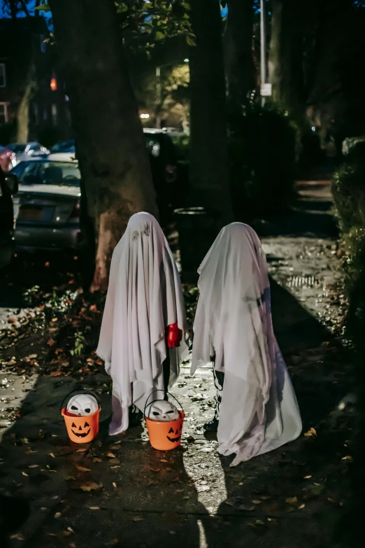 two ghosts standing next to each other on a sidewalk, pexels, happening, trick or treat, helmet is off, rear-shot, vendors