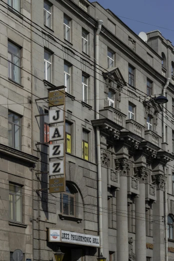 a tall building sitting on the side of a street, inspired by Jakub Różalski, art nouveau, jazz quintet, old signs, on a great neoclassical square, russian cinema