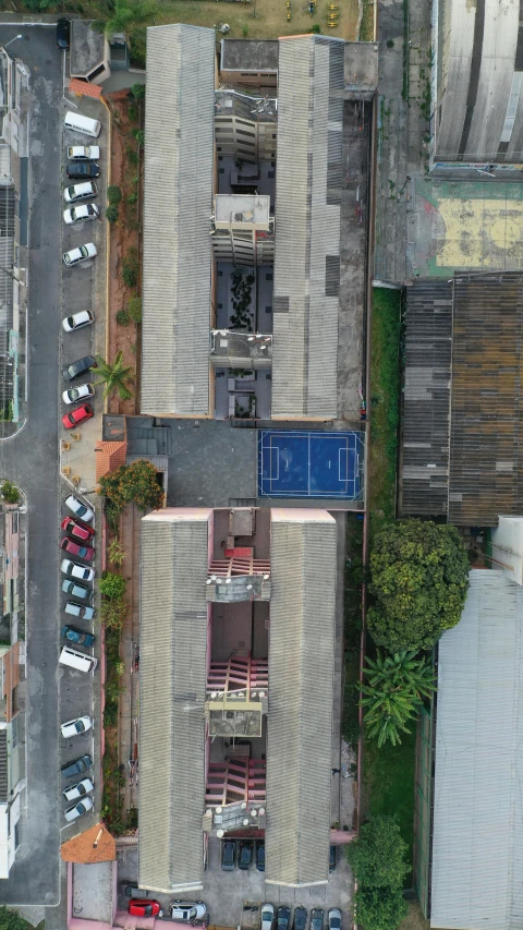 an aerial view of a parking lot in a city, an album cover, unsplash, quito school, low quality photo, building facing, 8k detail, alleys