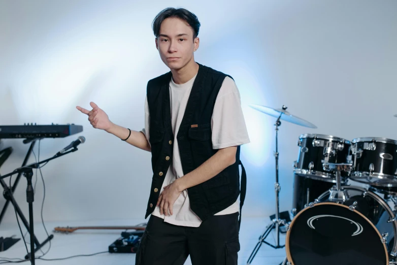 a man standing in front of a drum set, inspired by Gang Hui-an, unsplash, realism, wearing a vest, wearing casual clothing, avatar image, mid shot photo