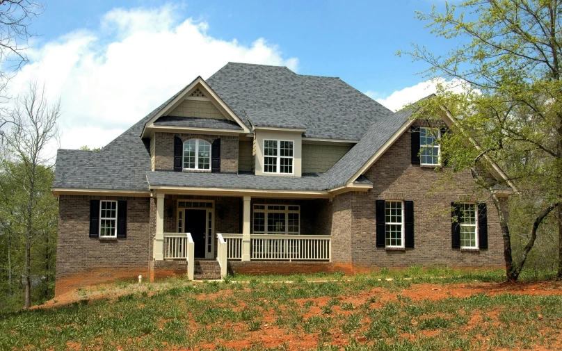 a house sitting on top of a lush green hillside, a photo, listing image, brick, construction, square