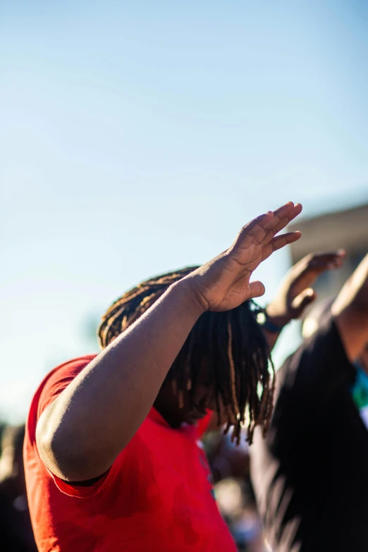 a group of people standing on top of a street, trending on unsplash, black arts movement, with his hands in his hair, block party, blue sky, closeup of fist