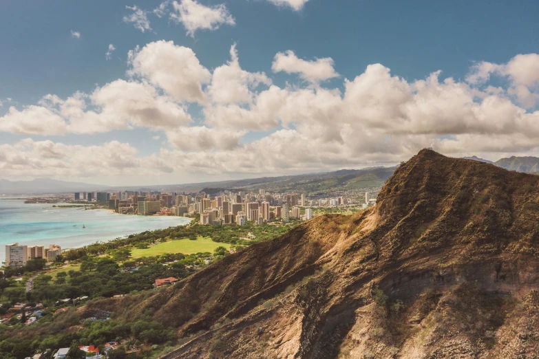 a view of the city from the top of a mountain, unsplash contest winner, hawaii beach, rising from mountain range, 2 0 0 0's photo, beautiful sunny day