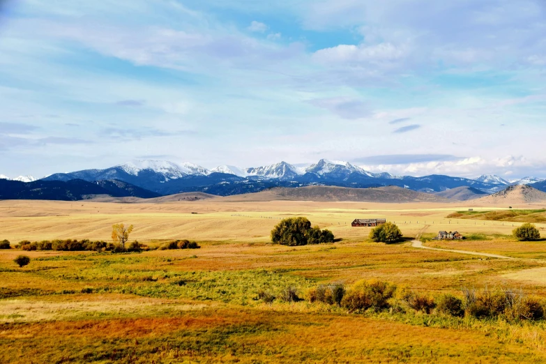 a large open field with mountains in the background, by Kristin Nelson, pexels contest winner, montana, background image, panorama distant view, conde nast traveler photo