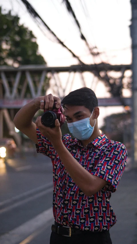 a man wearing a face mask taking a picture, by Abidin Dino, unsplash, shot on sony alpha dslr-a300, lgbtq, teenage boy, phot