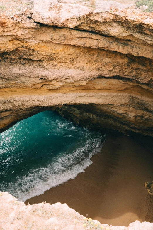 a man standing on top of a cliff next to the ocean, a cave painting, by Daniel Seghers, pexels contest winner, inside the curl of a wave, australian beach, an archway, slide show