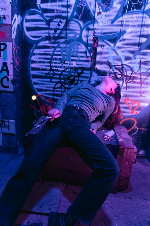 a man laying on the ground in front of a graffiti covered wall, inspired by David LaChapelle, pexels contest winner, happening, in a cyberpunk themed room, wax figure, slightly drunk, pulling the move'the banshee '