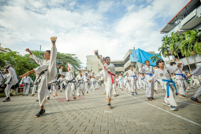 a group of people that are standing in the street, inspired by Baiōken Eishun, pexels contest winner, happening, capoeira, white uniform, on the concrete ground, malaysian