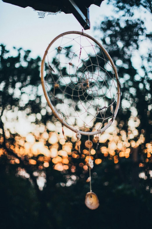 a person holding a dream catcher in their hand, an album cover, pexels contest winner, land art, evening lights, afternoon hangout, bright rim light, ✨🕌🌙