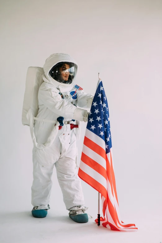 a man in an astronaut suit holding an american flag, trending on unsplash, light and space, woman, white, wearing a fancy dress, chemistry