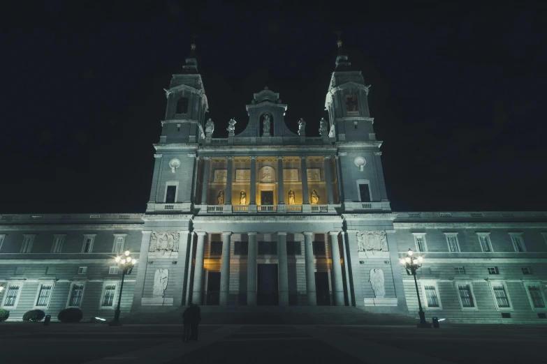 a large white building lit up at night, by Pablo Rey, unsplash contest winner, hyperrealism, cathedral, madrid, symmetrical front view, grey