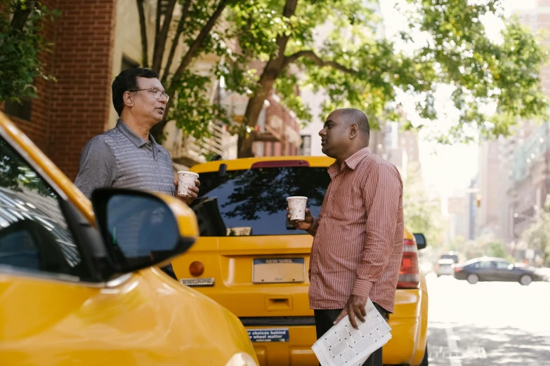 a couple of men standing next to a yellow car, happening, in new york city, avatar image, thumbnail, talking