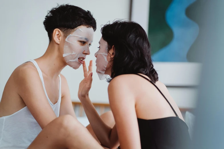 a couple of people sitting on top of a bed, a hyperrealistic painting, trending on pexels, face mask, lesbian kiss, silicone skin, asian face