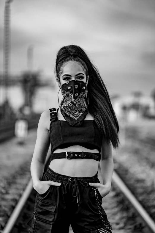 a woman wearing a mask standing on a train track, a black and white photo, inspired by Xi Gang, afrofuturism, bandanas, portrait of vanessa morgan, with black pigtails, techwear