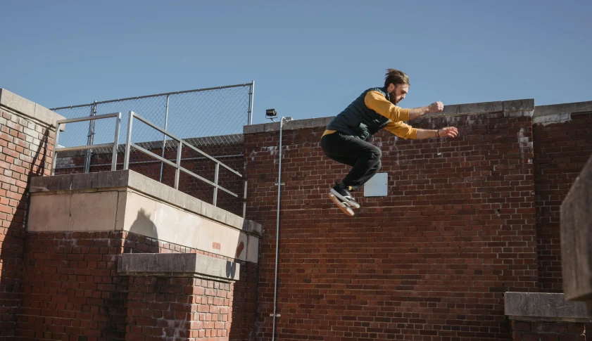 a man flying through the air while riding a skateboard, unsplash, bricks flying, live-action archival footage, high walls, lachlan bailey