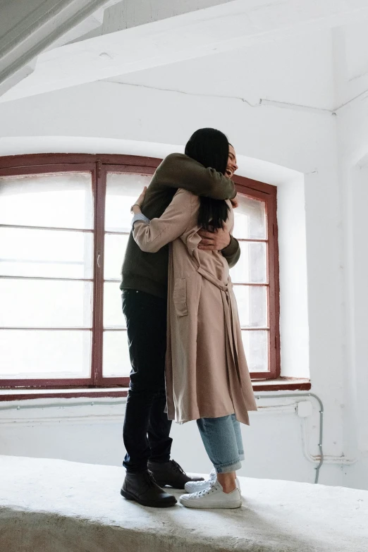 a couple of people standing on top of a bed, hugging, next to a window, strong emotional impact, commercially ready