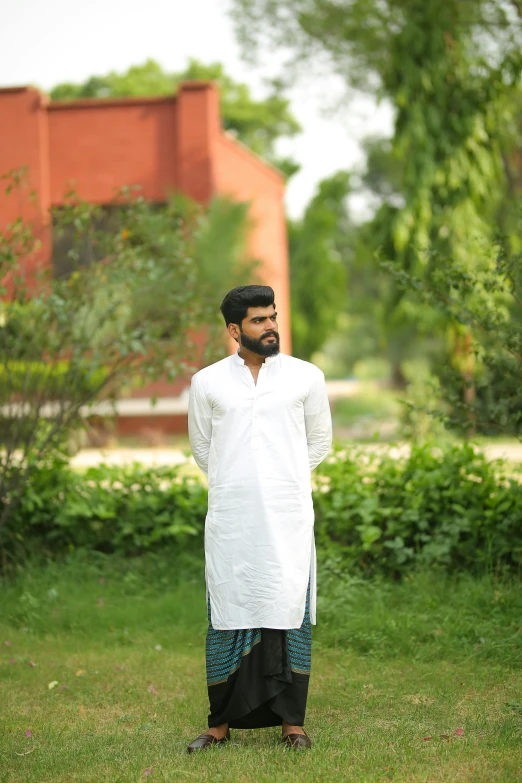 a man in a white shirt standing in the grass, by Riza Abbasi, pexels contest winner, wearing a kurta, full body model, profile image, ( ( theatrical ) )