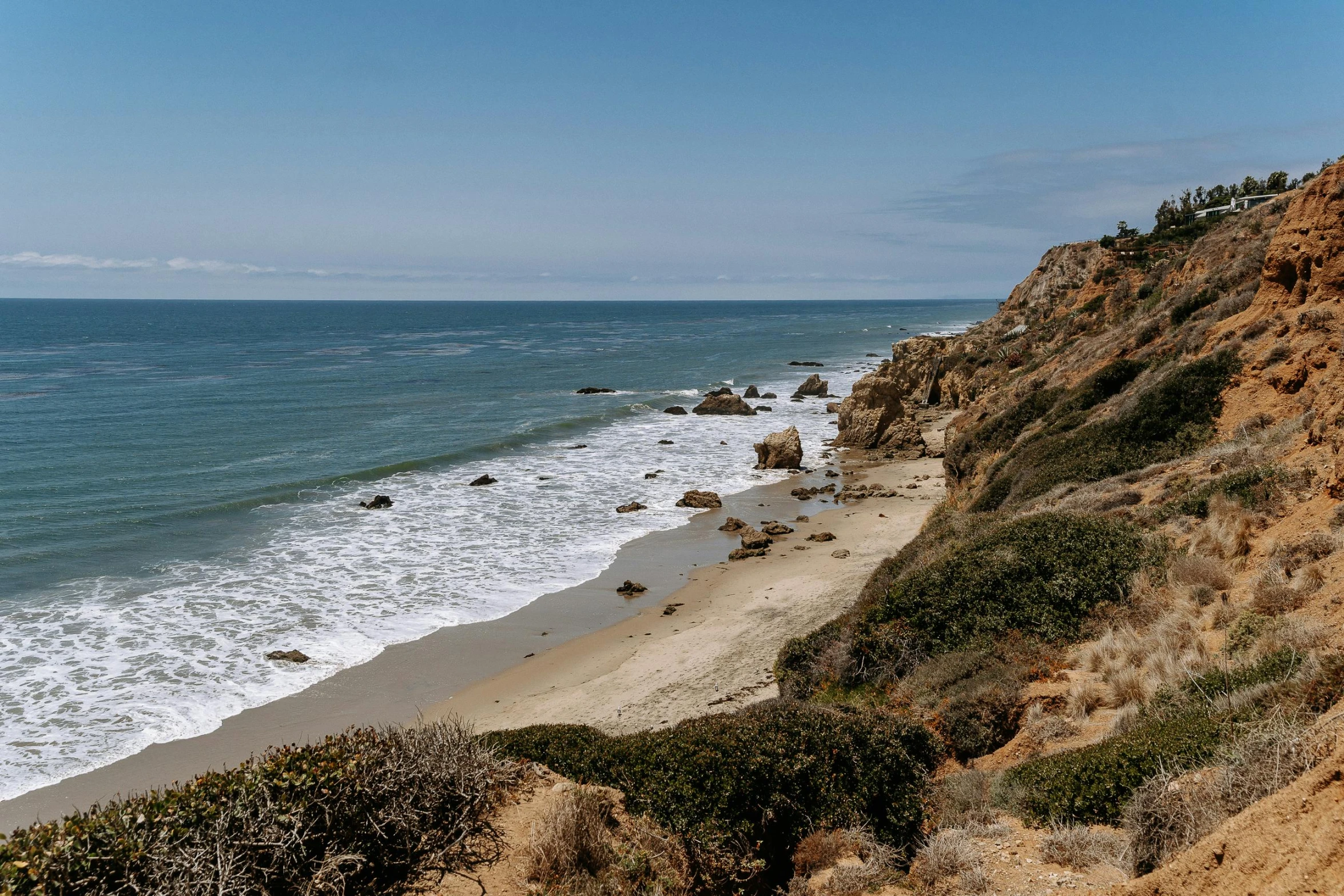 a view of a beach from the top of a hill, by Kristin Nelson, unsplash, malibu canyon, thumbnail, rocky cliffs, slightly sunny weather