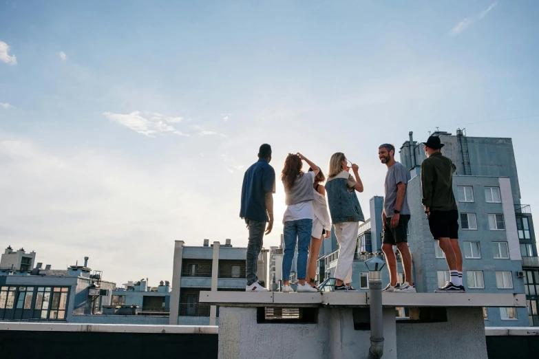 a group of people standing on top of a cement bench, pexels contest winner, happening, rooftop party, uniform off - white sky, view from side, sun overhead
