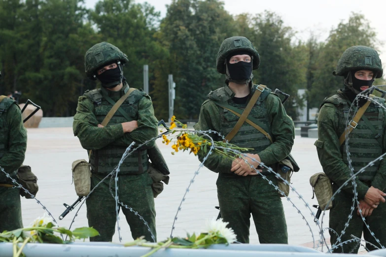 a group of soldiers standing next to each other, socialist realism, russia in 2 0 2 1, flowers in background, ap news, square