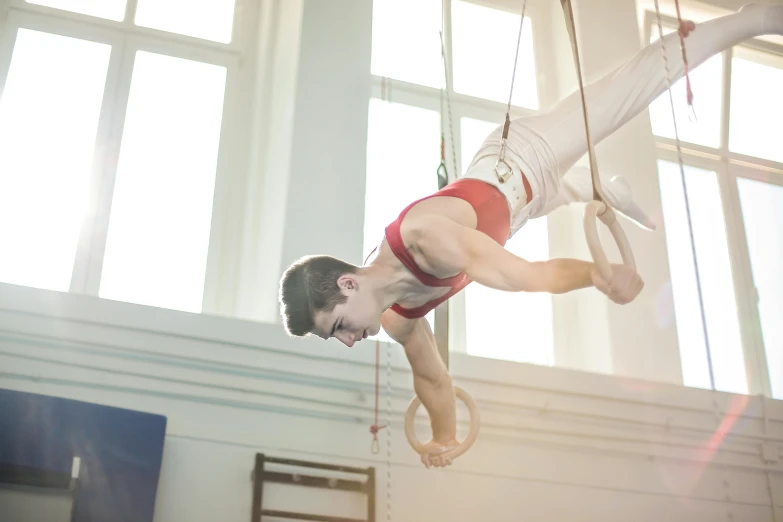 a man hanging upside down on a pair of rings, arabesque, avatar image, sports photo, thumbnail