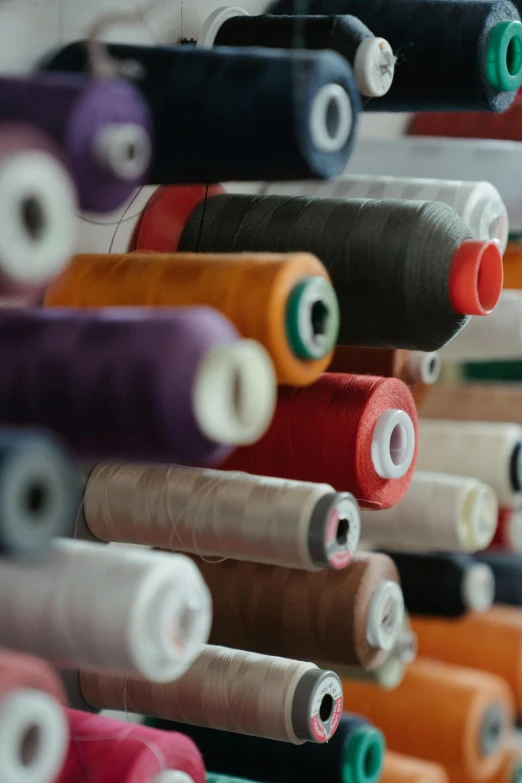 a close up of a bunch of spools of thread, a picture, by Daniel Taylor, patterned clothing, photographed for reuters, digital image, a tall