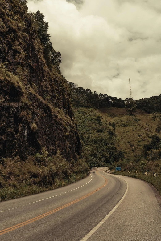 a man riding a motorcycle down a curvy road, by Elsa Bleda, visual art, philippines, 4 k cinematic photo, multiple stories, slate