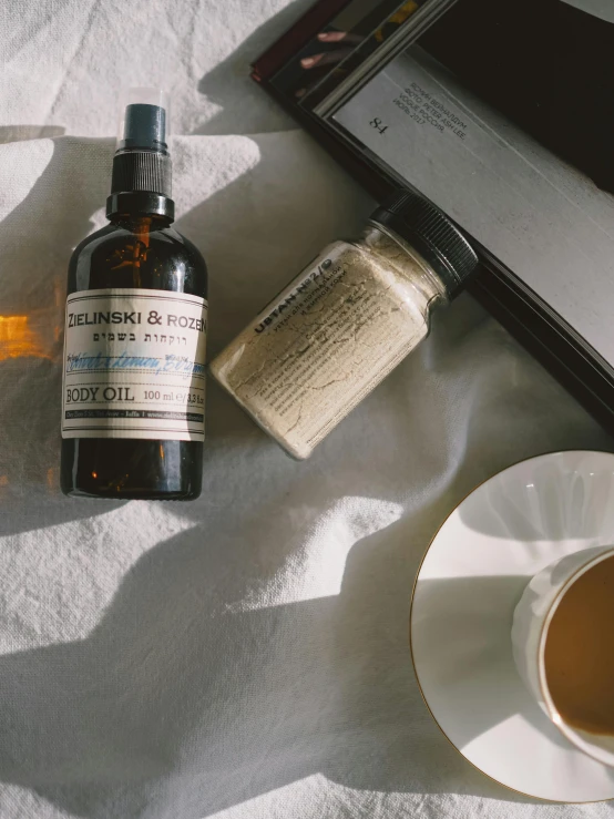 an open laptop computer sitting on top of a bed next to a cup of coffee, a still life, by Robbie Trevino, unsplash, process art, antique perfume, petroleum vitamin, product label, medium shot of two characters